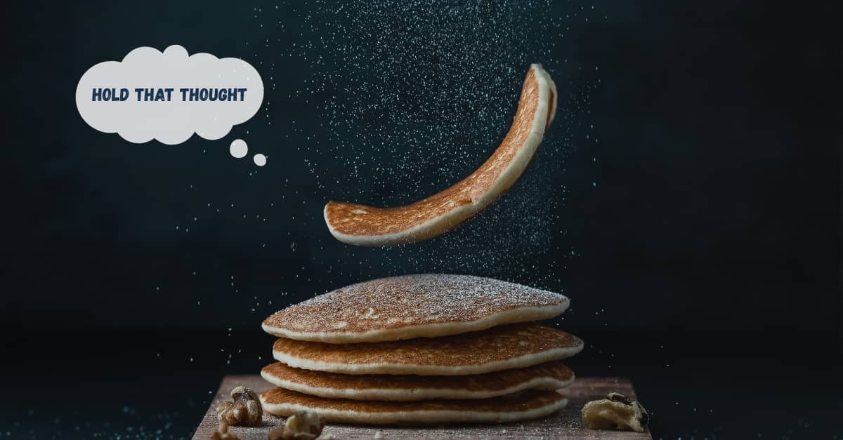 Stack of pancakes against a dark background that looks like a starry sky.
