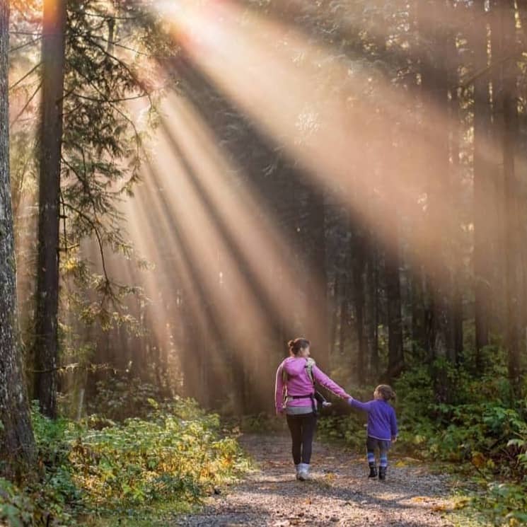 woman walking in forest with child