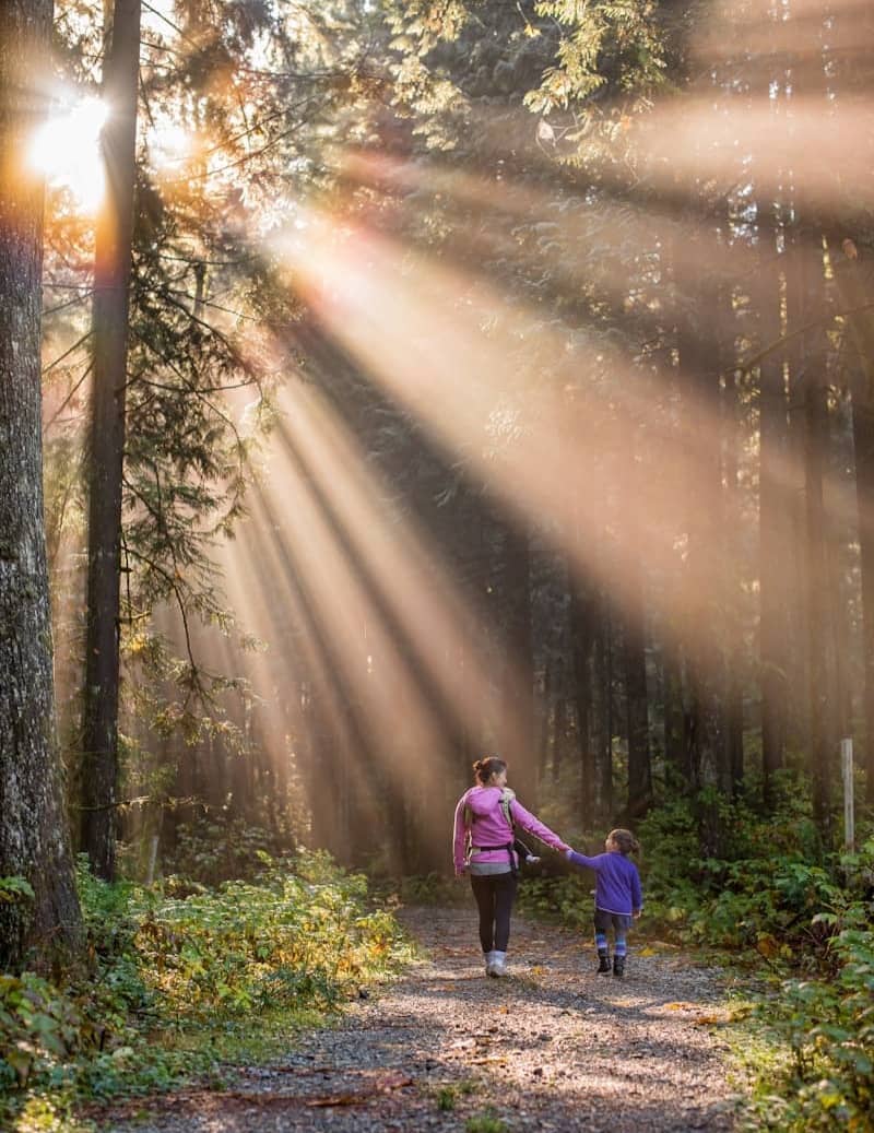 woman walking in forest with child