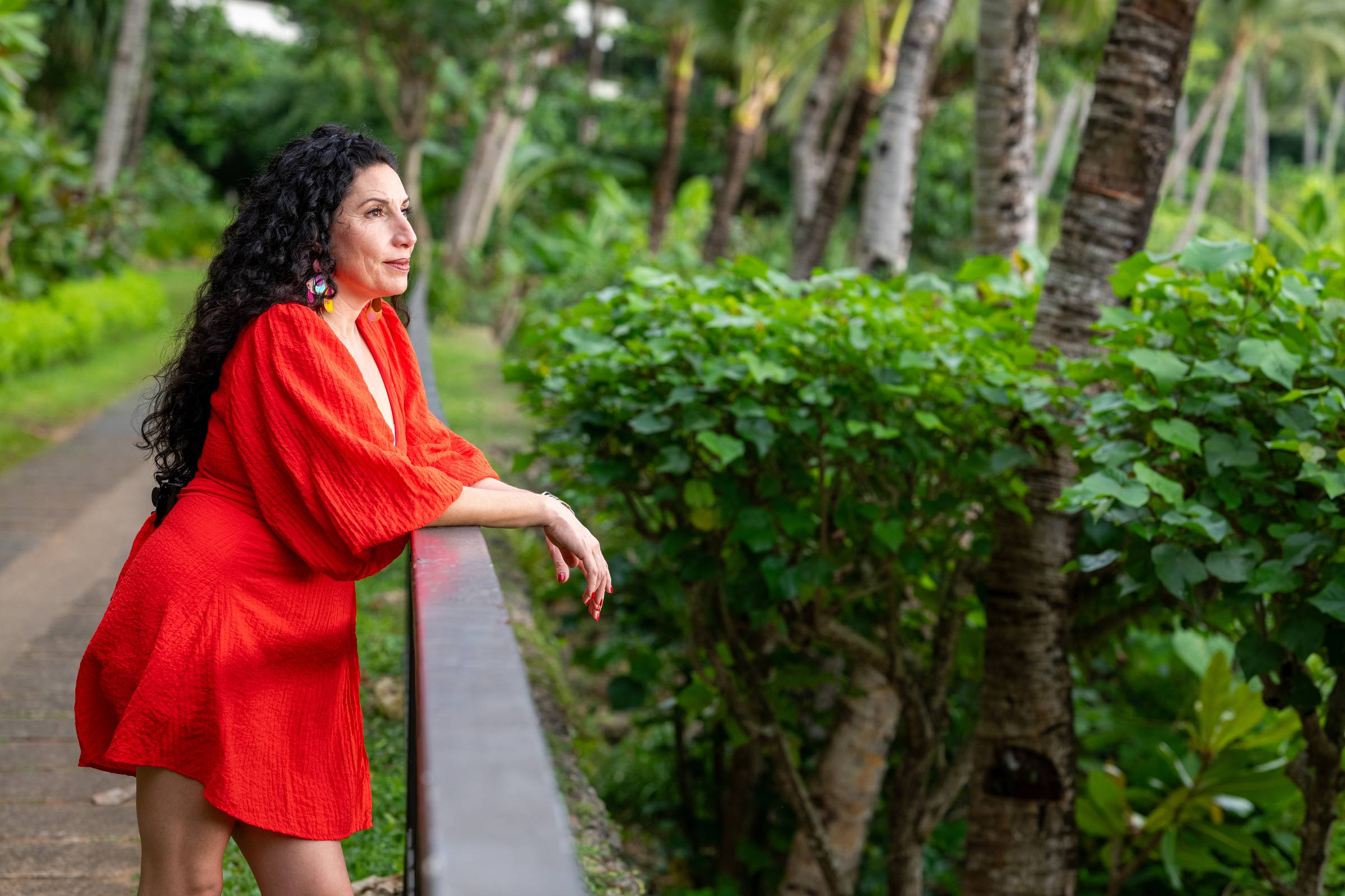 Maritza Schafer in a red dress looking out over a railing