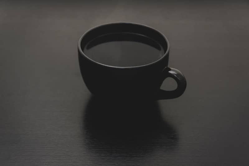 black ceramic mug with liquid close up photo