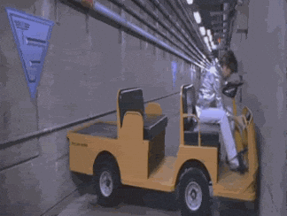gif from the movie austin powers is stuck driving a yellow cart, it's turned sideways in a long hallway and the gif endlessly loops as he fails to reverse or move forward