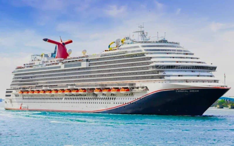 Carnival Dream, viewed from a front-side angle, with multiple stacked decks and rows of balcony cabins.