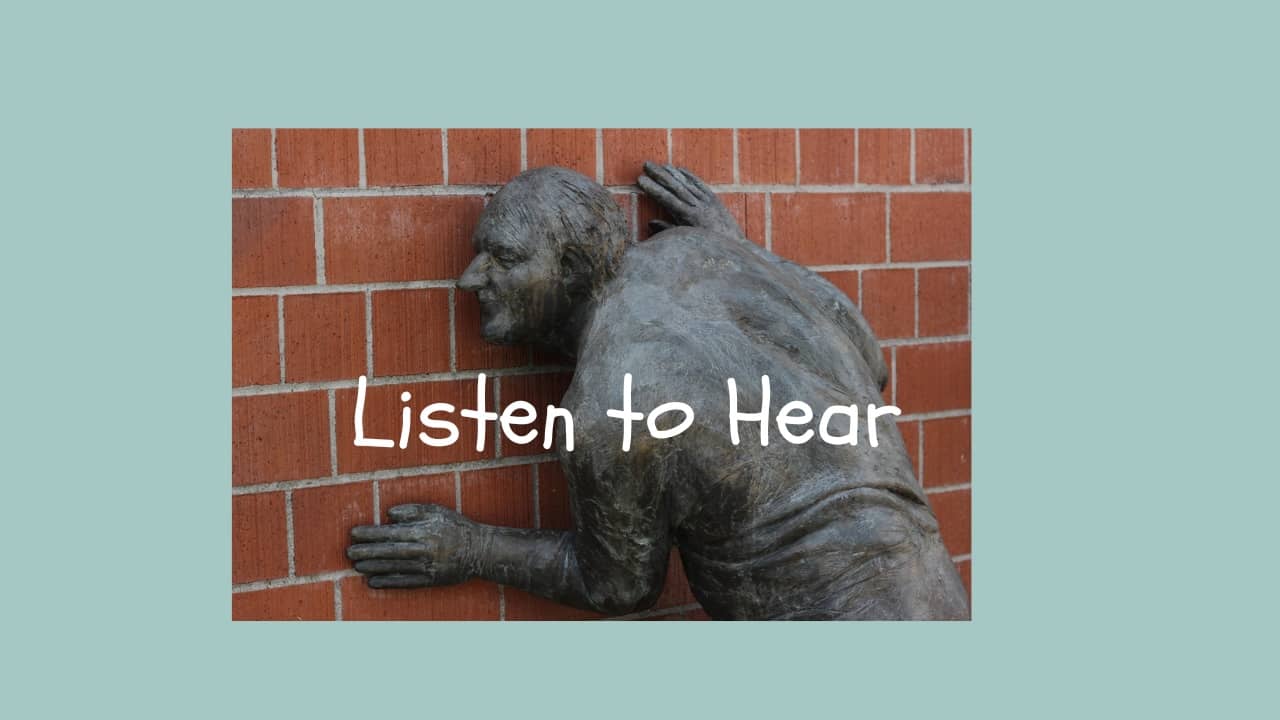 Listen to hear statue with ear on brick wall