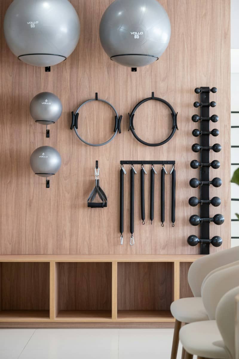 Gym equipment neatly organized on a wooden wall.