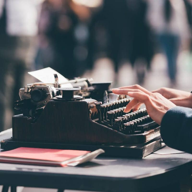 person using black typewriter