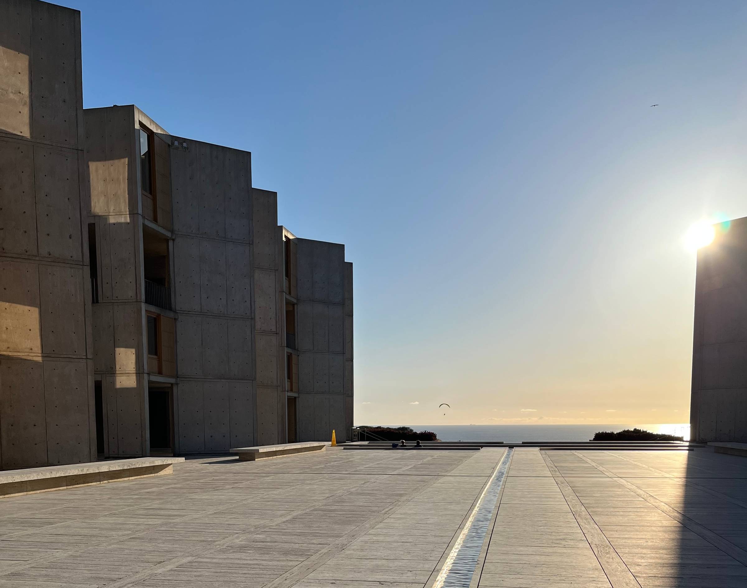 Salk Institute courtyard with the 'River of Life' rill, afternoon light, clear blue sky.