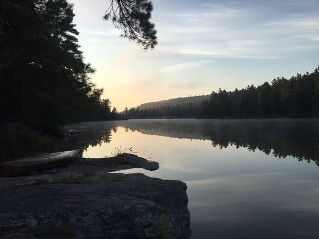 canoe on the shore by a calm lake