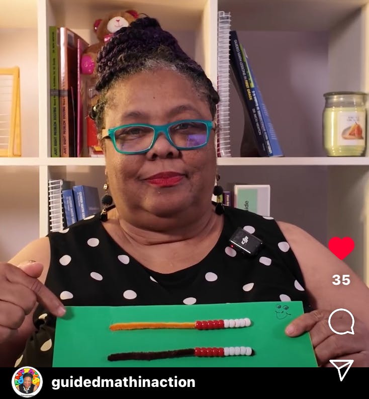 Woman looks at camera, holding up a Rekenrek made from pipecleaners and beads.