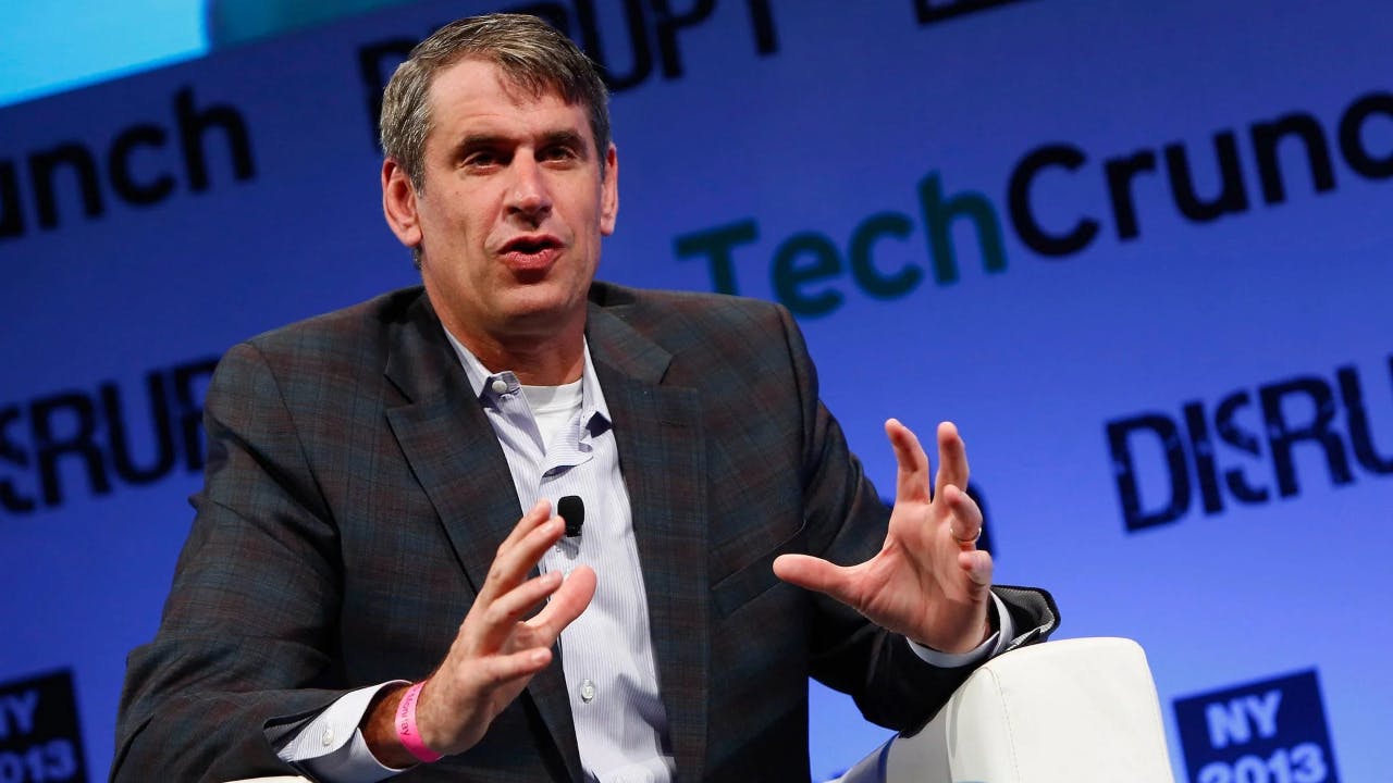 Photo of Bill Gurley seated on a stage, with a backdrop of logos for TechCruch Disrupt NY 2013.