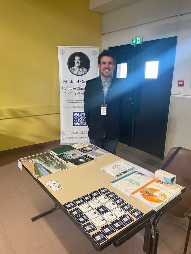 Une photo de Mickaël Coupat au salon du bien être avec son stand hypnose