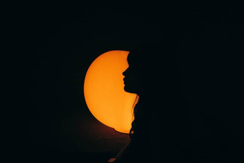 Silhouette of a person against a bright orange sun.