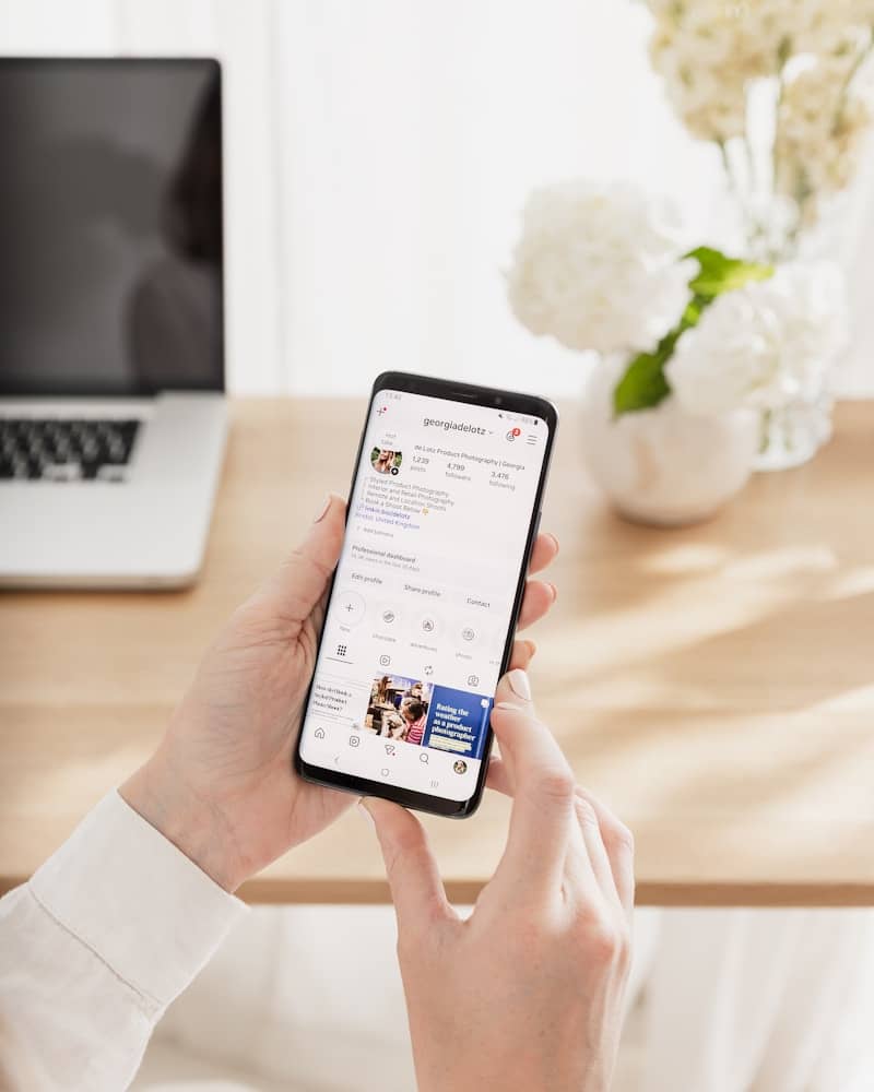 Hands scrolling social media feed on smartphone