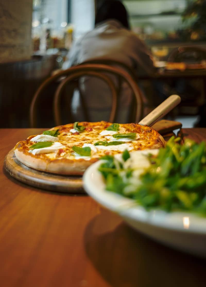Pizza and salad ready to be enjoyed at a restaurant.