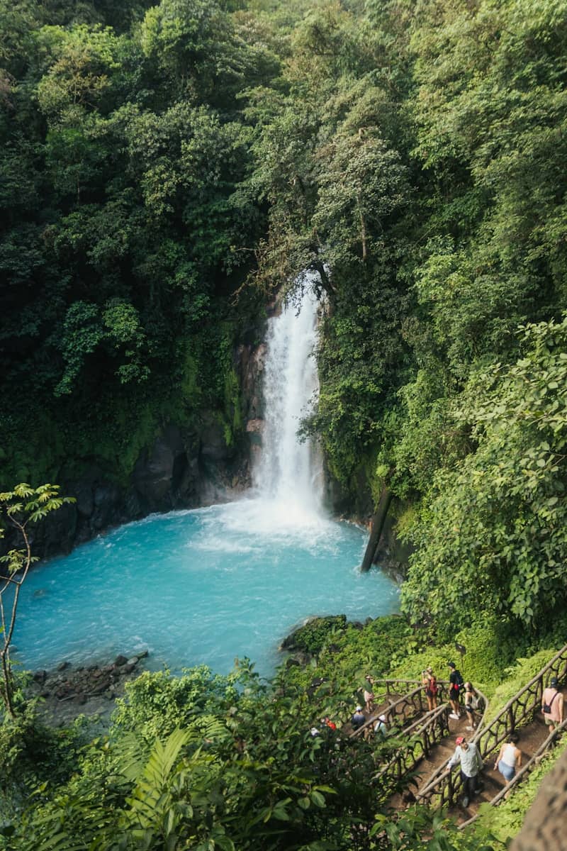 A group of people standing in front of a waterfall