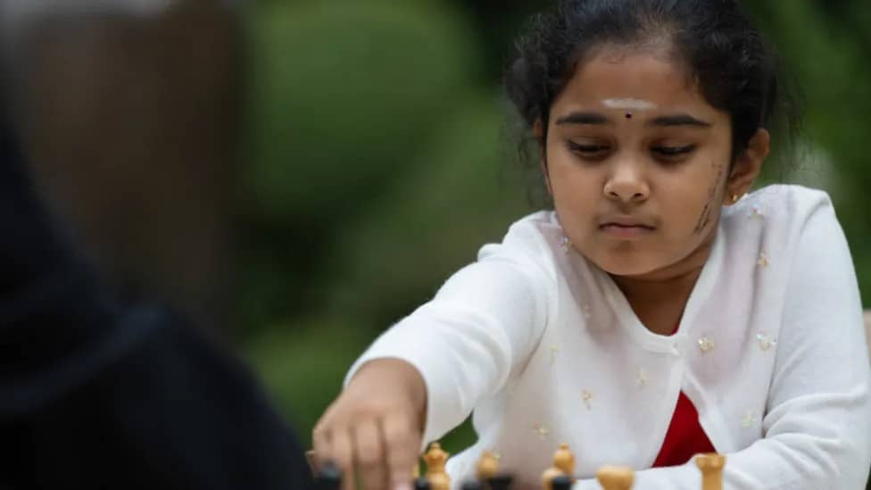 young girl playing chess in traditional dress