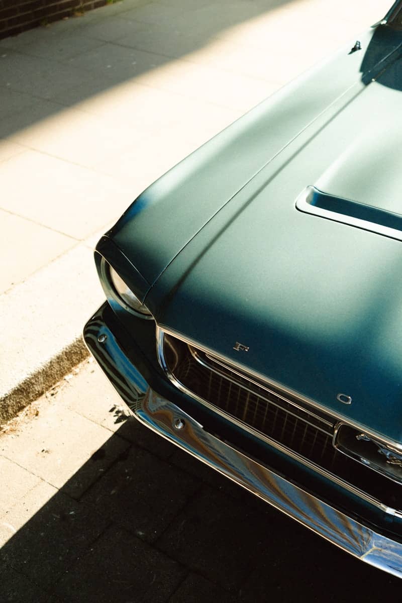 An antique ford mustang shines in the sunlight.