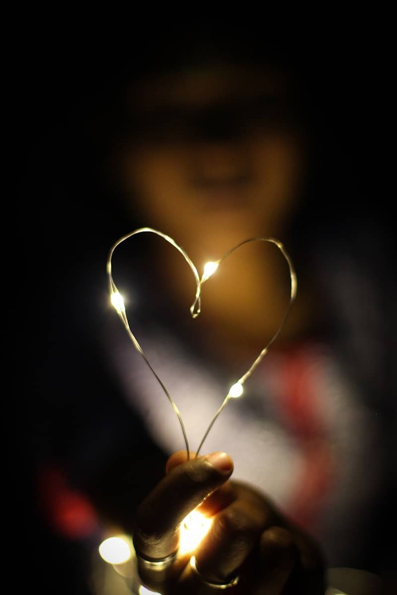 A person holding a string of lights in their hand