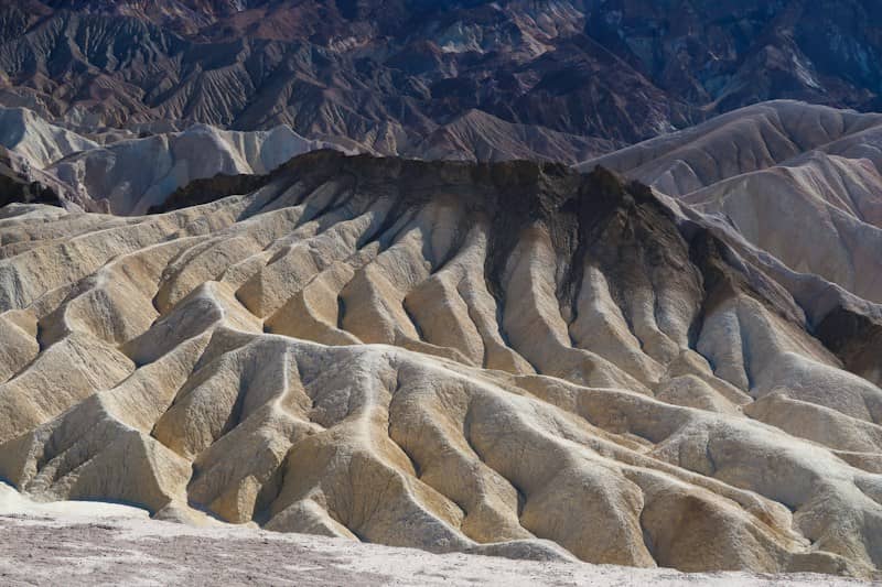 Eroded badlands with sharp ridges and deep shadows in Death Valley