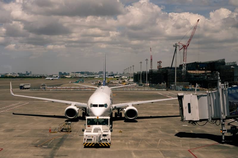 Airplane parked at airport gate with jet bridge attached