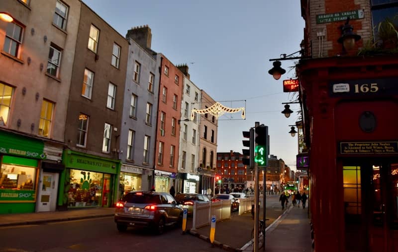 Evening street view of colorful buildings and moving traffic.