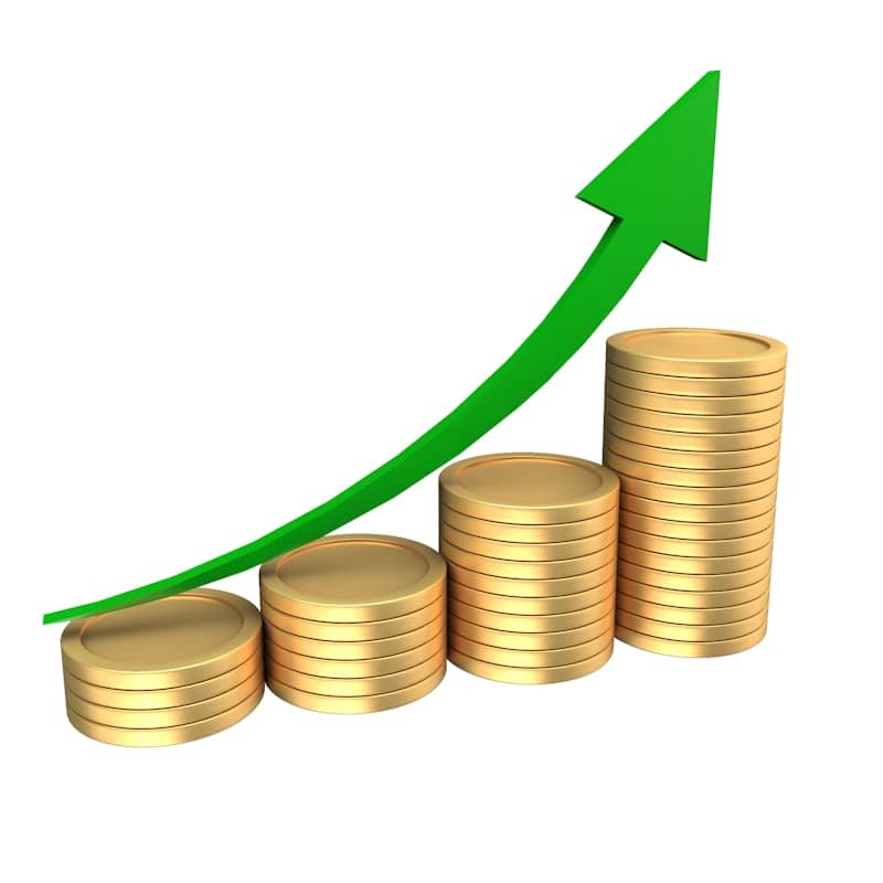 Stacks of coins with an upward trending green arrow
