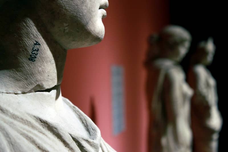 Close-up of a statue's neck with a number tattoo.