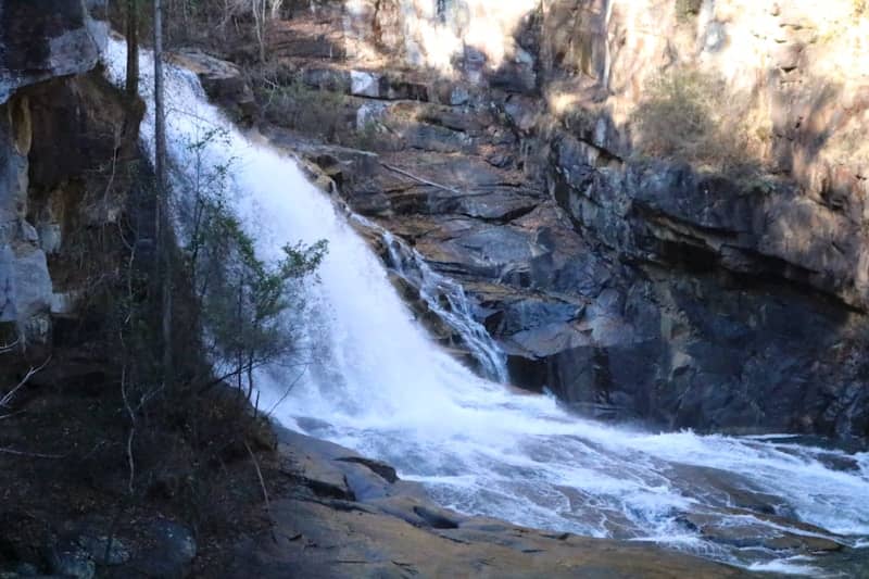 A powerful waterfall cascades down rocky terrain.