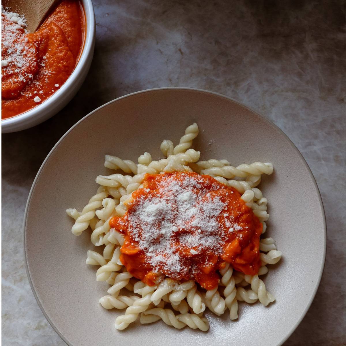 Bowl with boodles and homemade pasta sauce and sprinkled cheese