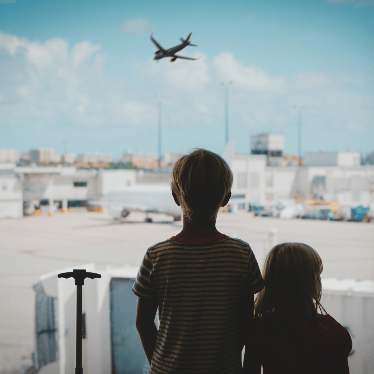 Two Kids Watching an Airplane in Sky
