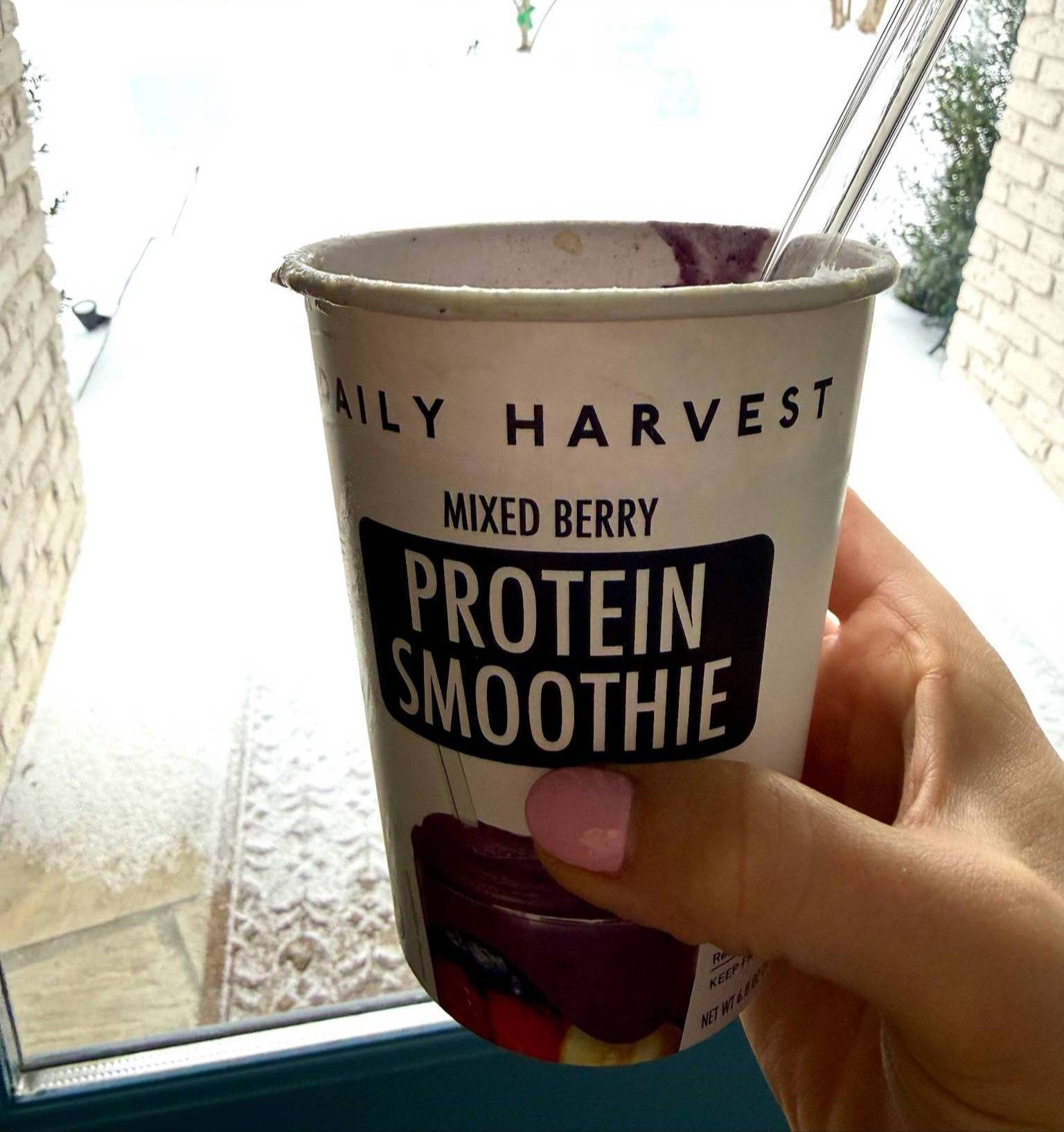 Hand holding Daily Harvest Smoothie.