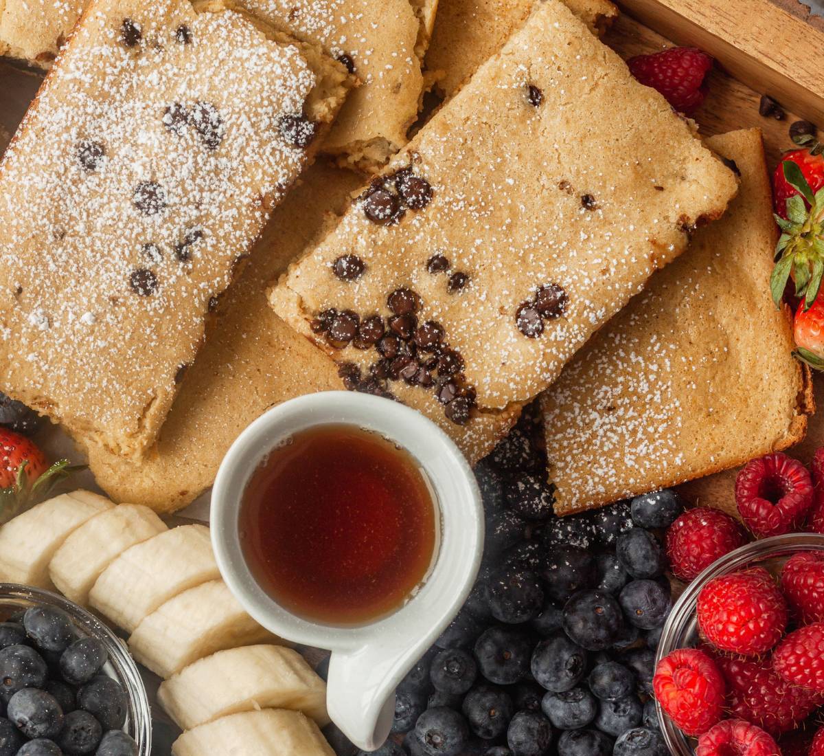 Sheet Pan Pancakes Cut in Rectangles With Syrup and Fruit