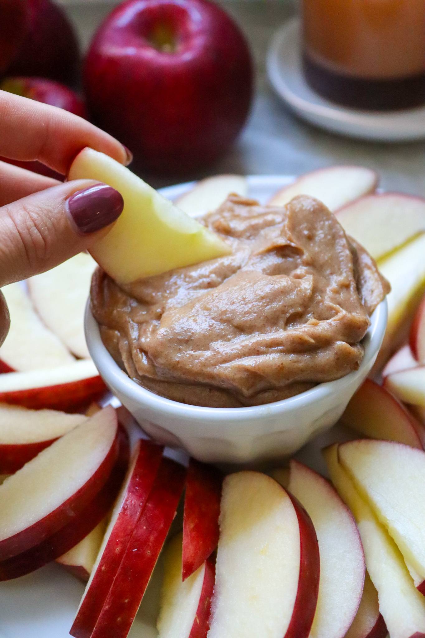 date caramel apple dip with hand dipping apple slice