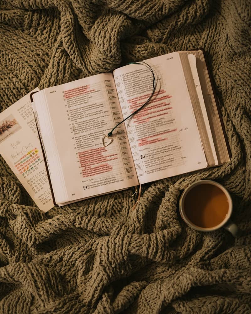 Open book with coffee and calendar on blanket