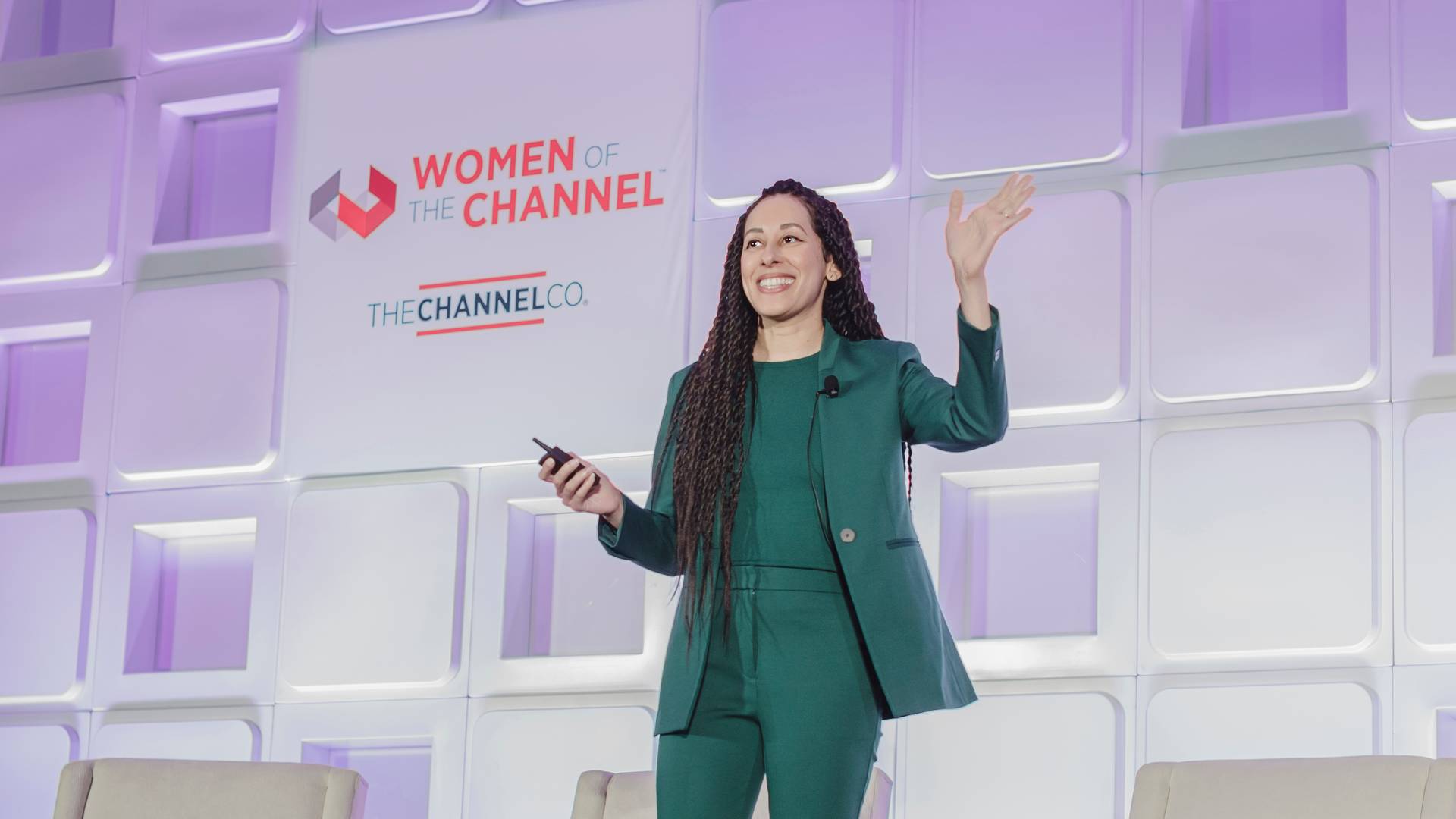 Jess Wass on stage after keynote talk in a green suit