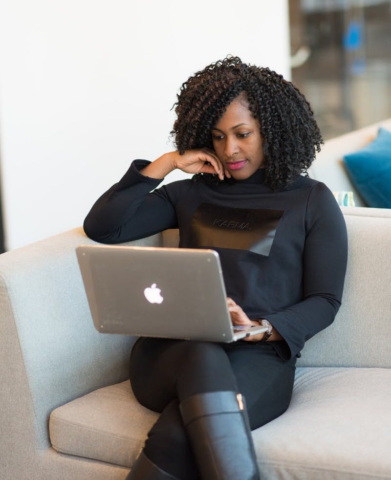 woman in black coat using MacBook