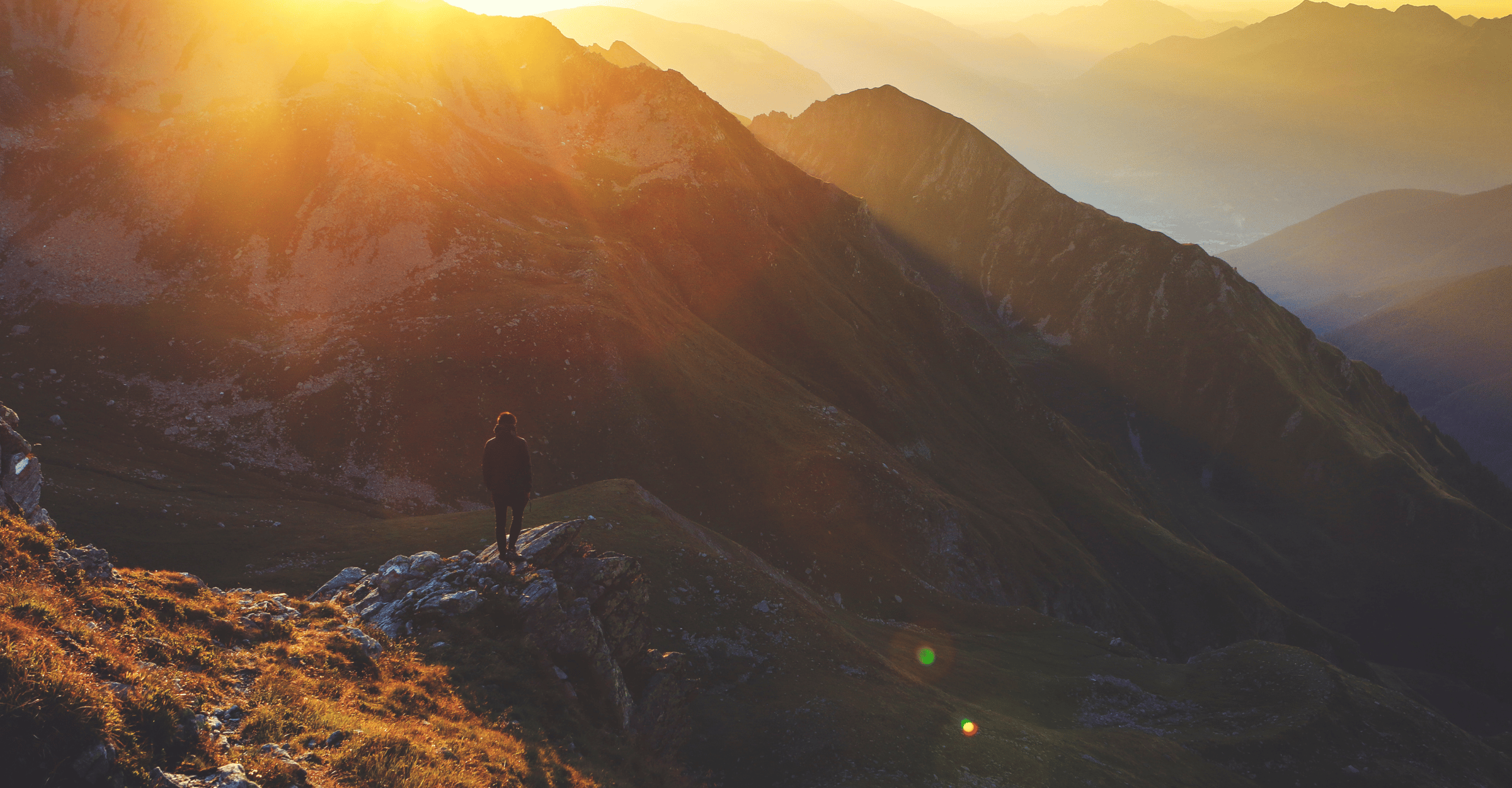 sun pouring over a mountain top