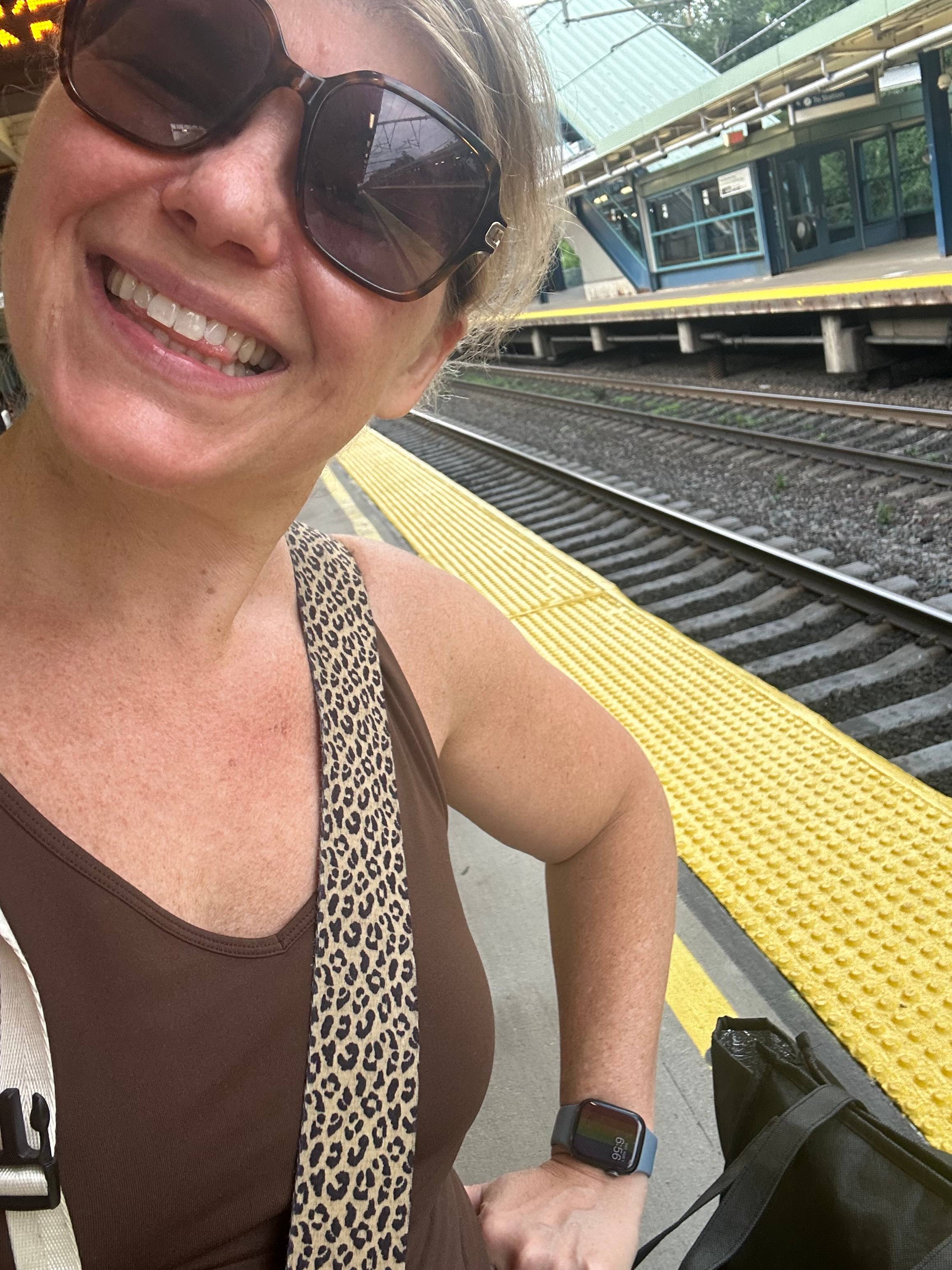 Marketing strategist Deborah C Smith stanging on a train track, smiling. 