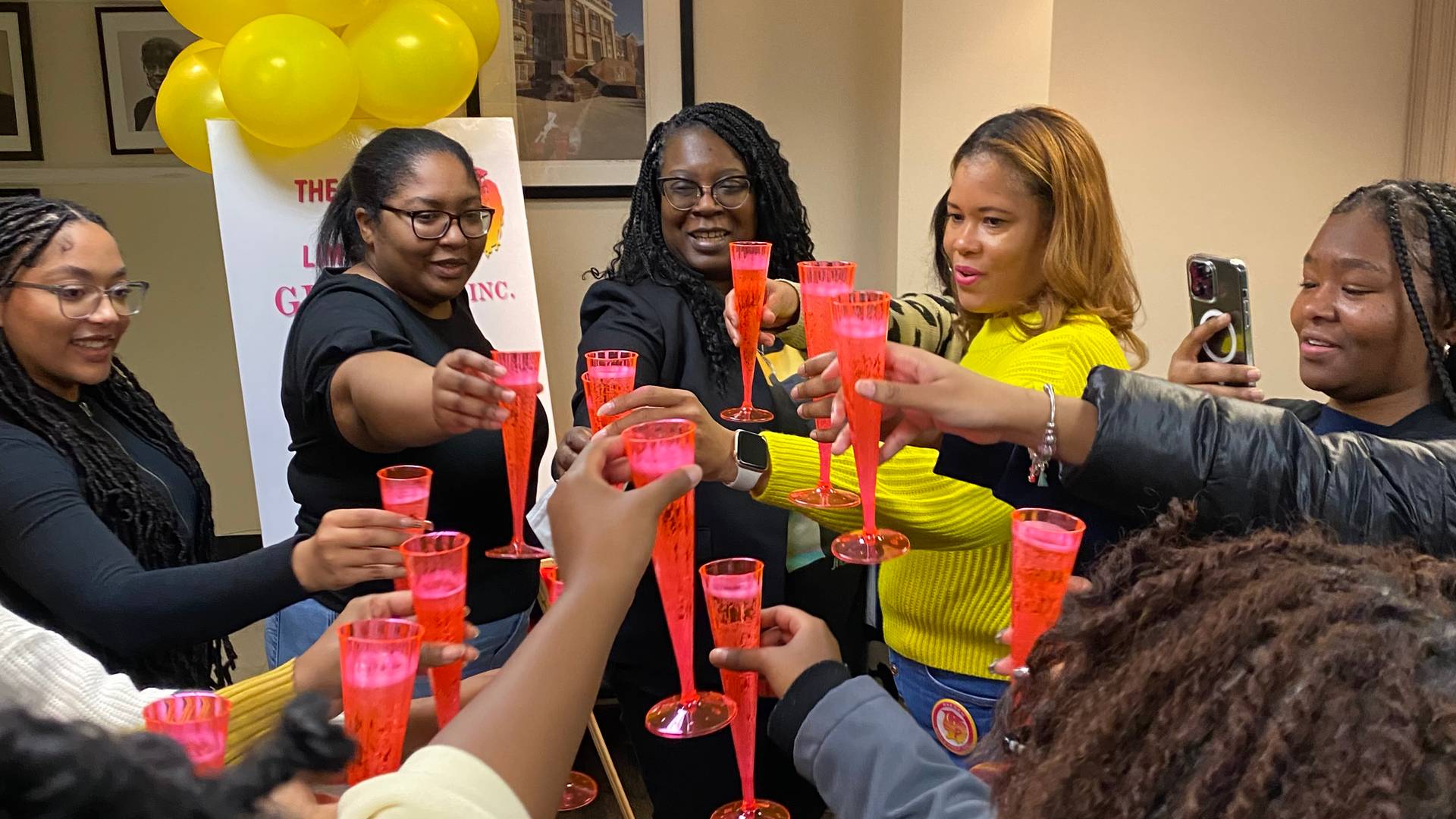 group of 8 women toasting sparkling apple cider  at an event pink glasses