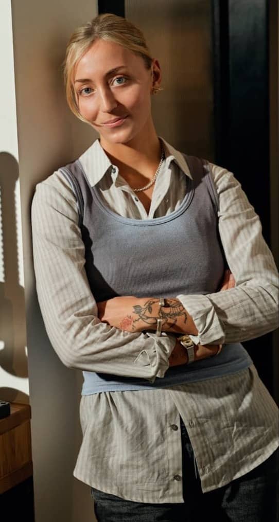 Woman standing with arms crossed in workshop.