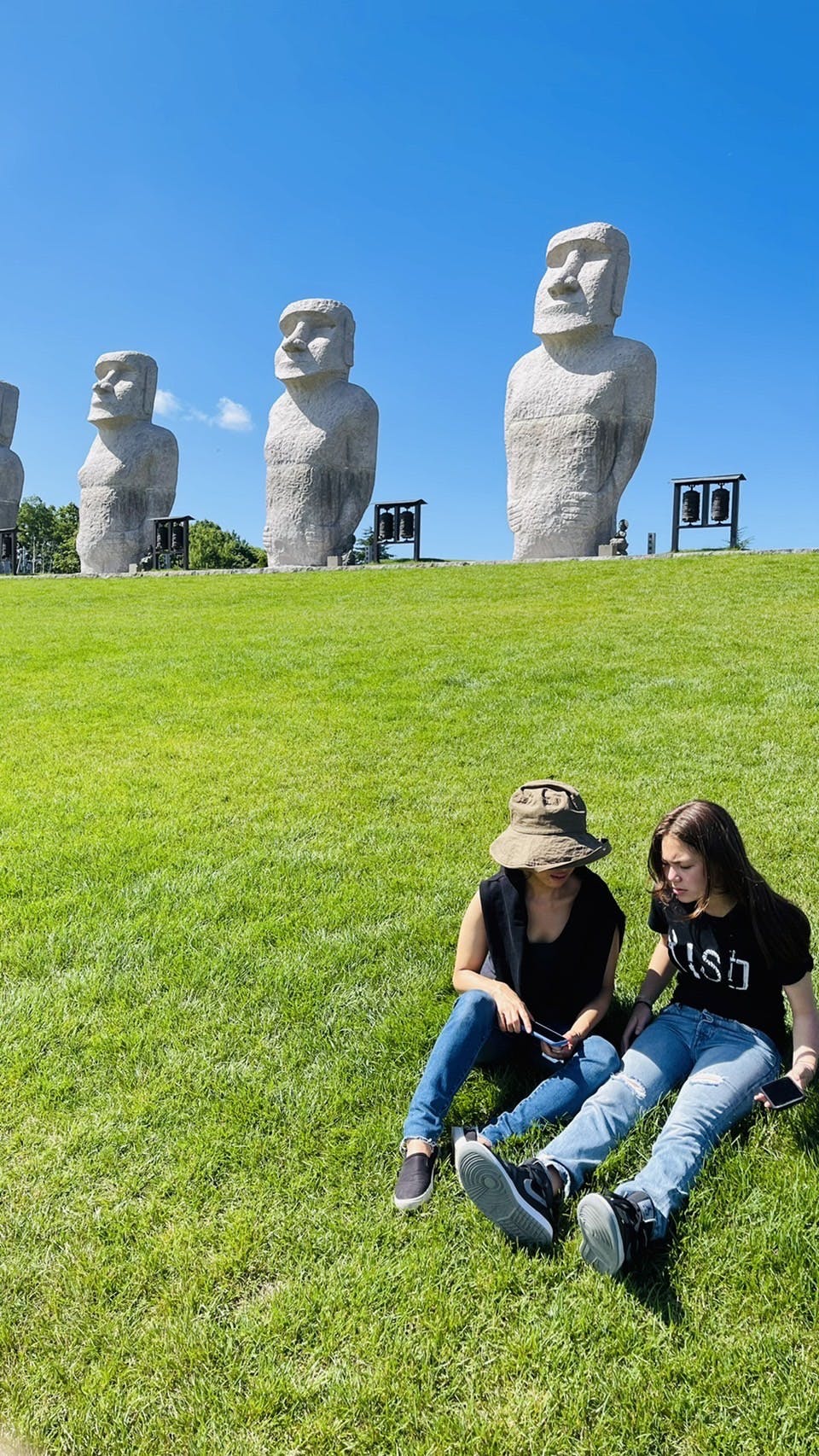 Mother and daughter on the lawn. Moai statues behind us. 