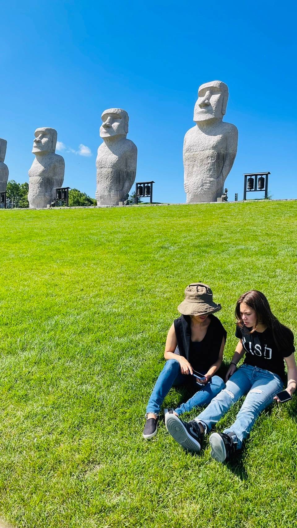 Mother and daughter on the lawn. Moai statues behind us. 