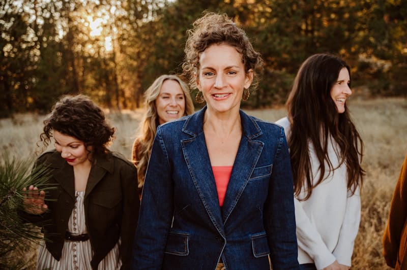 A group of women standing next to each other in a field