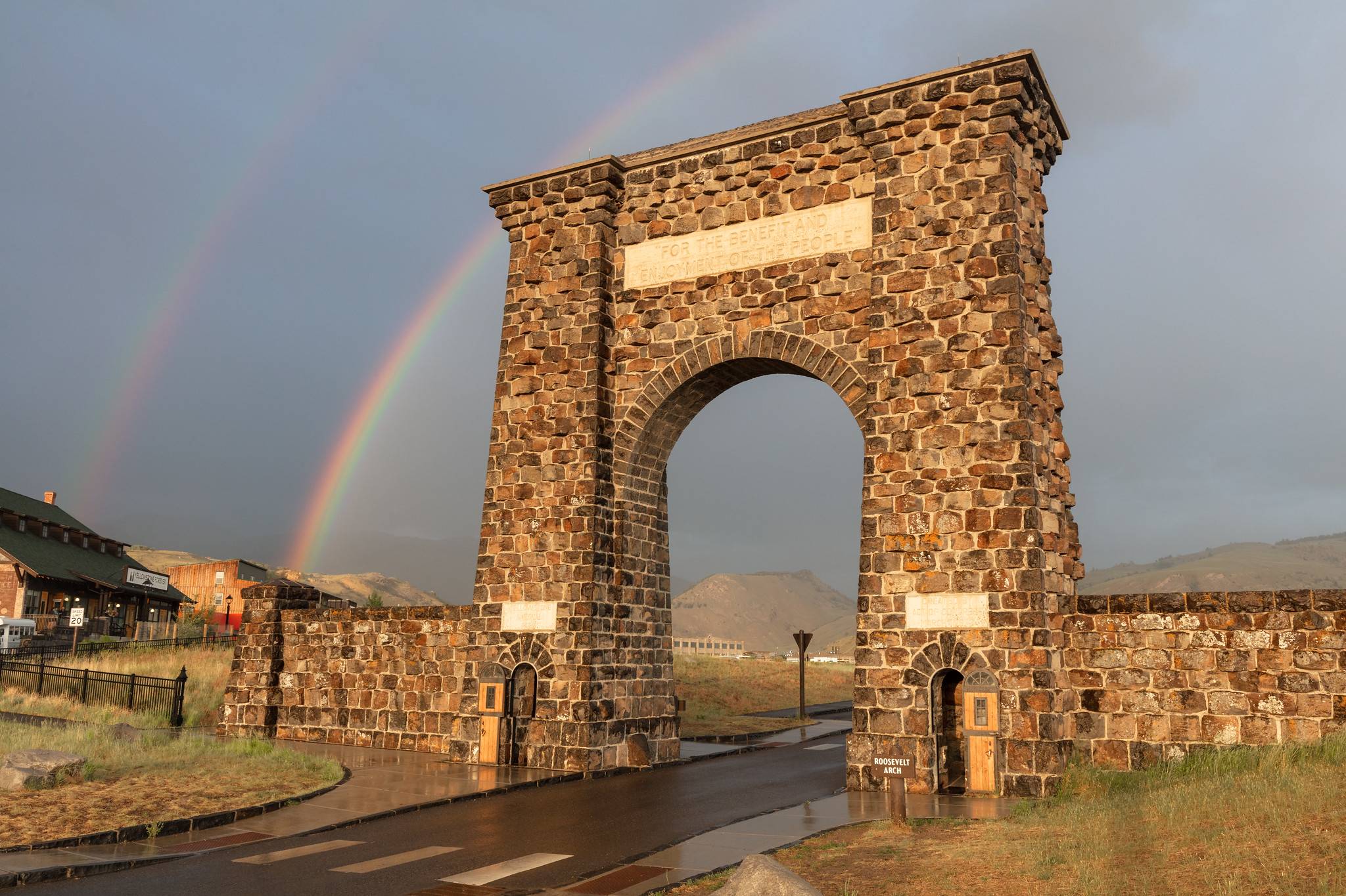 A rainbow appears behind the Roosevelt Arch in Gardiner, Montana.