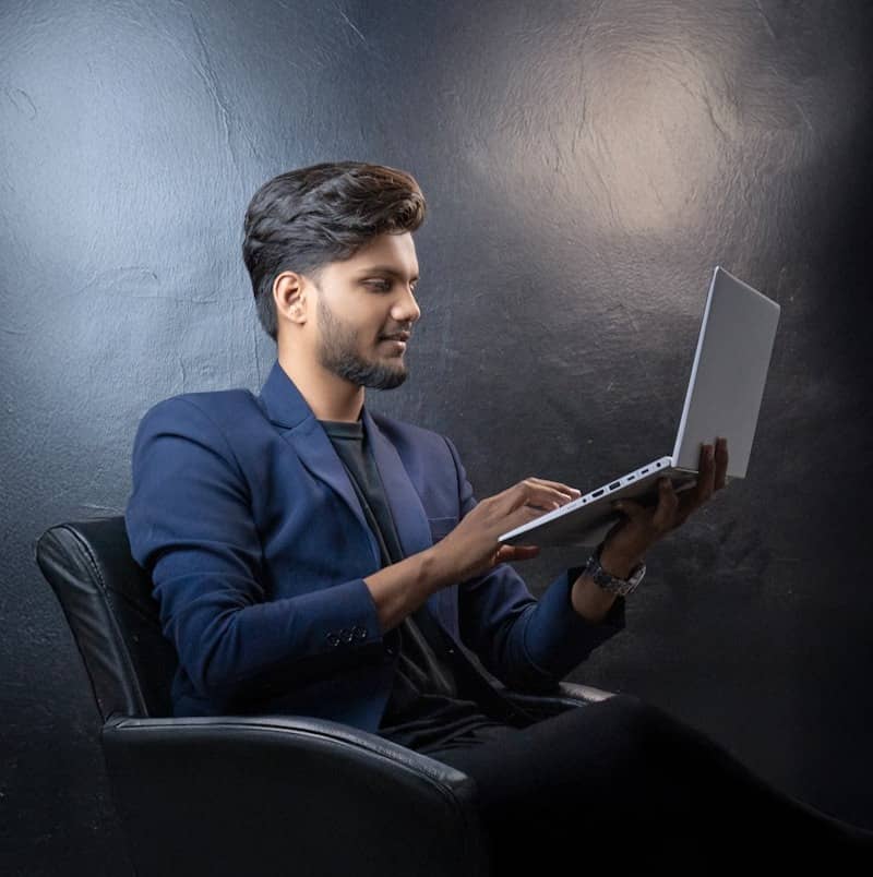 Professional man sitting, using a laptop.