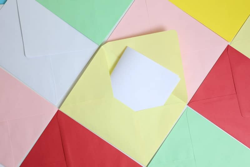 Colorful envelopes arranged in a pattern with one open.