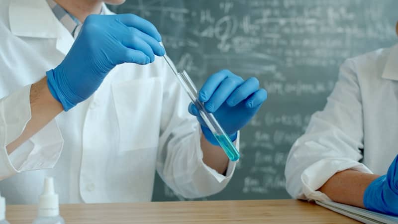 Scientists in lab coats working with test tubes