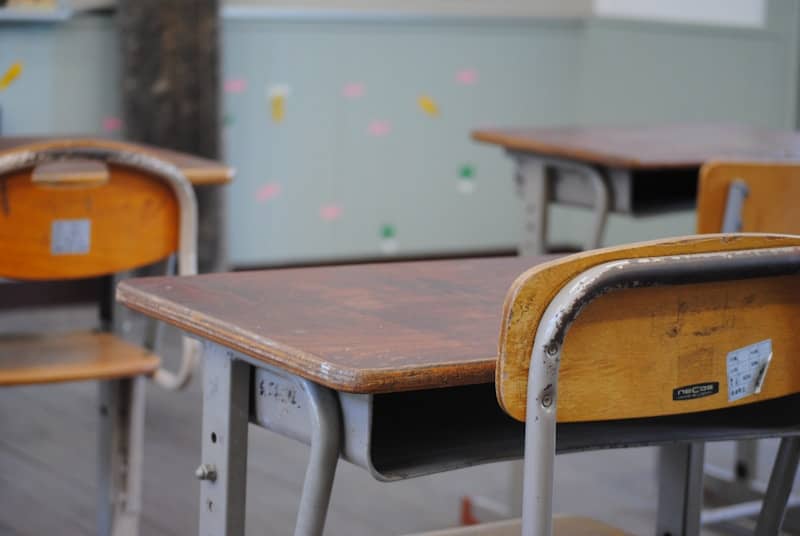 A row of wooden school desks in a classroom