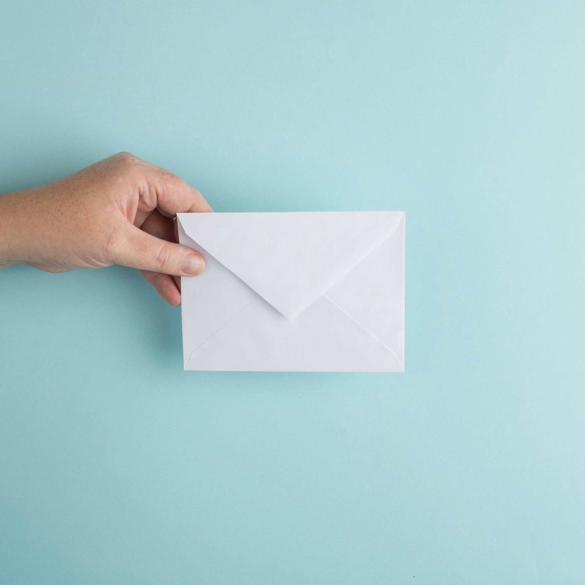 person holding a white envelope