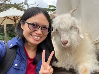 Photo of me (one GOAT) doing the peace sign next to a goat. (GOAT stands for Greatest of All Time)